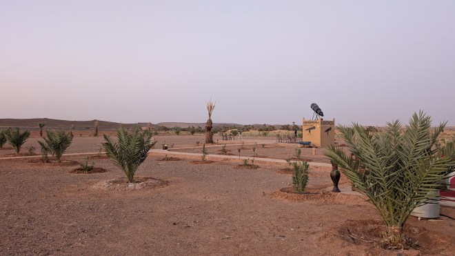 A view of the desert with a huge telescope and pathways