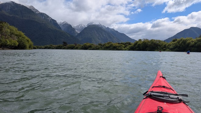 A kayak in a river with tall mountains
